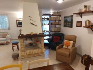 a living room with a fireplace and a couch and chairs at Casa sotto la Quercia in Citta' Sant'Angelo