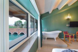 a bathroom with a tub and a view of a bridge at CABANON urban apartments in Peschiera del Garda