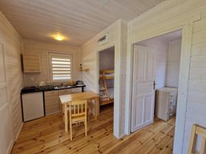 維契的住宿－Na Wydmie，一个带木桌和门的小厨房