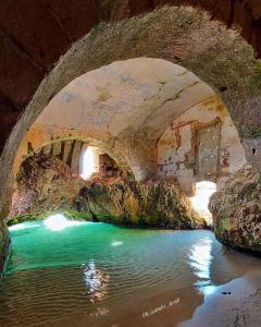 una grotta con un fiume sotto un ponte di Corte Gabellone - dimora storica a Nardò