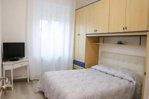 a bedroom with a white bed and a television at La Casa di Piccolì di Gabriele Martelli e Catia Pacetti - APPARTAMENTO in Ancona +3 photos