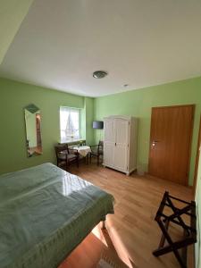 1 dormitorio con paredes verdes, 1 cama y escritorio en Ferien und Freizeithof Engelau - Zi 3, en Giekau