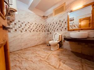 y baño con aseo y lavamanos. en Snow Clad Riverview Hotel & Resort, Manali, en Manali