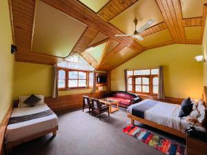 a bedroom with two beds and a wooden ceiling at Snow Clad Riverview Hotel & Resort, Manali in Manāli