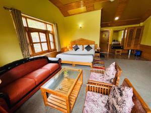 a living room with a bed and a couch at Snow Clad Riverview Hotel & Resort, Manali in Manāli