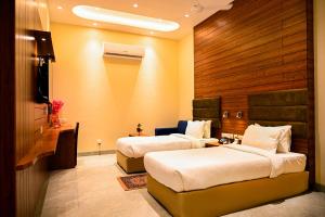 a hotel room with two beds and a television at Cresent Villa in Varanasi