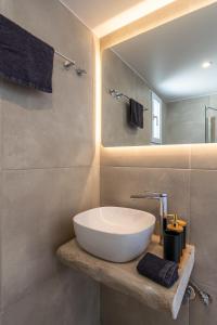 Un baño con un lavabo blanco y un espejo. en Sunset studio in Plaka, en Plaka Milou