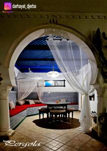Habitación con sofá y mesa con cortina en Dar hayat en Djerba