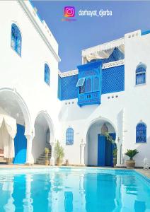 a swimming pool in the courtyard of a building at Dar hayat in Djerba