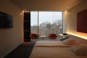 a hotel room with a bed and a large window at D-Hotel in Kortrijk