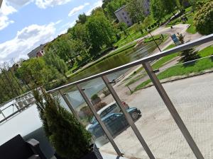 een auto geparkeerd op een straat gezien vanaf een balkon bij Apartament Mazury Mrągowo nad jeziorem. in Mrągowo