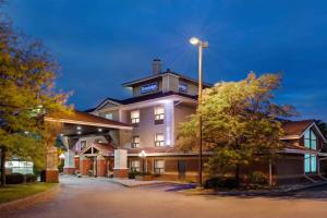 un bâtiment d'hôtel avec une lumière au-dessus dans l'établissement Travelodge by Wyndham Oshawa Whitby, à Oshawa