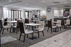 a dining room with tables and chairs and a clock at Wingate by Wyndham Savannah Pooler in Savannah