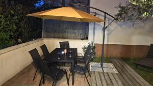 einen Tisch und Stühle unter einem Sonnenschirm auf einer Terrasse in der Unterkunft Apartment with garden in Barbariga in Barbariga
