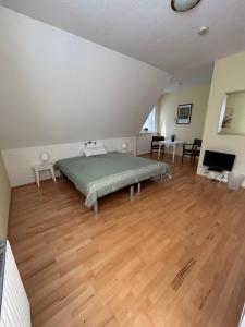 1 dormitorio con 1 cama y suelo de madera en Ferien und Freizeithof Engelau - Zi 2 en Giekau