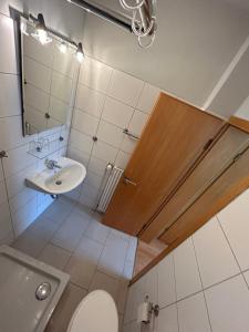 y baño con lavabo, aseo y espejo. en Ferien und Freizeithof Engelau - Zi 2 en Giekau