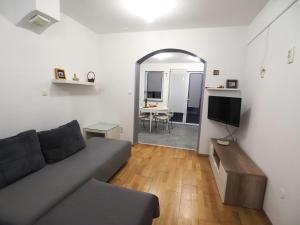 uma sala de estar com um sofá, uma mesa e um espelho em Apartment with garden in Barbariga em Barbariga