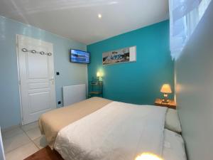 a bedroom with a bed and a blue wall at Aux pieds des pistes 4/6 personnes in Gérardmer