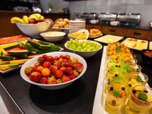a buffet with bowls of fruit on a table at Mercure Opole in Opole