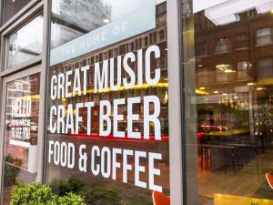 a sign in the window of a food and coffee shop at ibis London City - Shoreditch in London