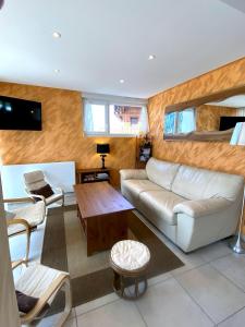 ein Wohnzimmer mit einem Sofa und einem Tisch in der Unterkunft Aux pieds des pistes 4/6 personnes in Gérardmer