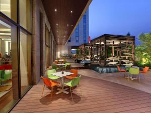 Un balcón con mesas y sillas en un edificio en ibis New Delhi Aerocity - An Accor Brand en Nueva Delhi