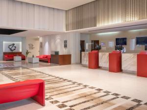 a lobby with red furniture and a checkerboard floor at ibis New Delhi Aerocity - An Accor Brand in New Delhi