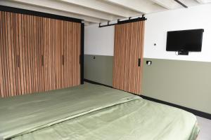 a bedroom with a bed and a flat screen tv at Villa met 13 slaap plaatsen in Alphen