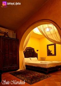 Dar hayat في Djerba: غرفة نوم بها سرير مع ممر