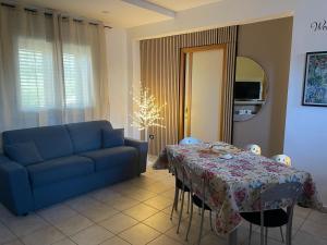a living room with a table and a blue couch at Belvedere Lacinio -Casa Vacanze- in Crotone