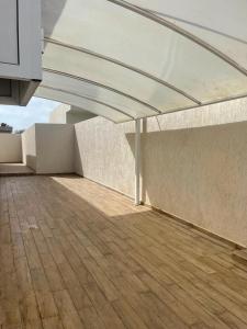 a patio with awning on a building with a wooden floor at Villa mima in Midoun