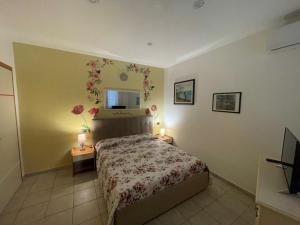 1 dormitorio con 1 cama y TV en la pared en Belvedere Lacinio -Casa Vacanze-Villaggio Casarossa, en Crotone