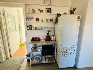 uma cozinha com um frigorífico branco e uma mesa em Delight at Golf em Auckland