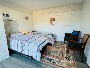 a bedroom with two beds and a chair at Delight at Golf in Auckland