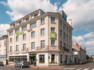 a white building on the corner of a street at ibis Styles Saumur Gare Centre in Saumur