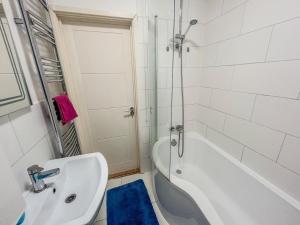 a white bathroom with a tub and a sink at 1 Bedroom Apartment By The River in High Wycombe