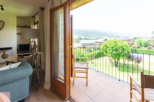 a living room with a couch and a balcony at Dúplex a Age amb piscina in Puigcerdà