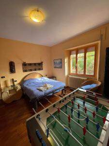 Appartamento vacanze في Ravigliano: غرفة نوم بسرير وطاولة بلياردو