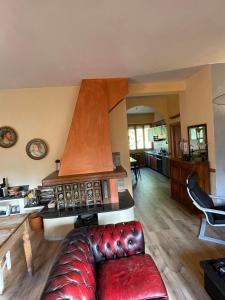 Appartamento vacanze في Ravigliano: غرفة معيشة مع أريكة حمراء في مطبخ