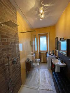 Appartamento vacanze في Ravigliano: حمام مع مغسلتين ودورتين مياه
