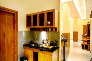 a kitchen with wooden cabinets and a black counter top at Cresent Villa in Varanasi