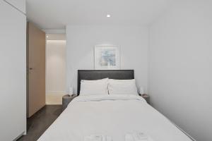 a bedroom with a large bed with white sheets at The Shore 7 Coogee Beach in Sydney