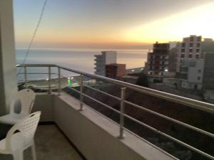 a balcony with a view of the ocean at sunset at Plage in Douar Chaïb Rasso