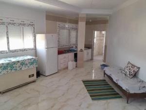a large kitchen with a refrigerator and a couch at Plage in Douar Chaïb Rasso