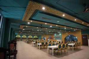 a dining hall with tables and chairs in a restaurant at Basant Haveli in Roorkee