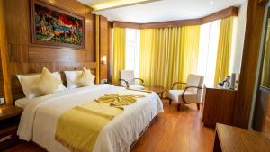 a bedroom with a large bed with a yellow blanket at HillView Munnar in Munnar