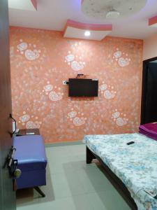 een slaapkamer met een bed en een tv aan de muur bij Hotel Atithi Galaxy in Kānpur