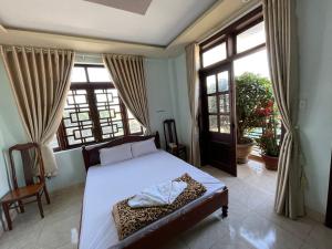 a bedroom with a bed and a large window at Manh Hung Hotel in Buon Ma Thuot