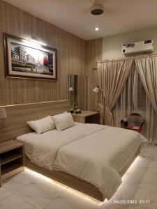 - une chambre avec un grand lit blanc et un bureau dans l'établissement Sunset BnB, à Karachi
