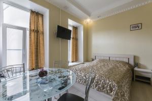 1 dormitorio con cama y mesa de cristal en Studio Avrora, en San Petersburgo